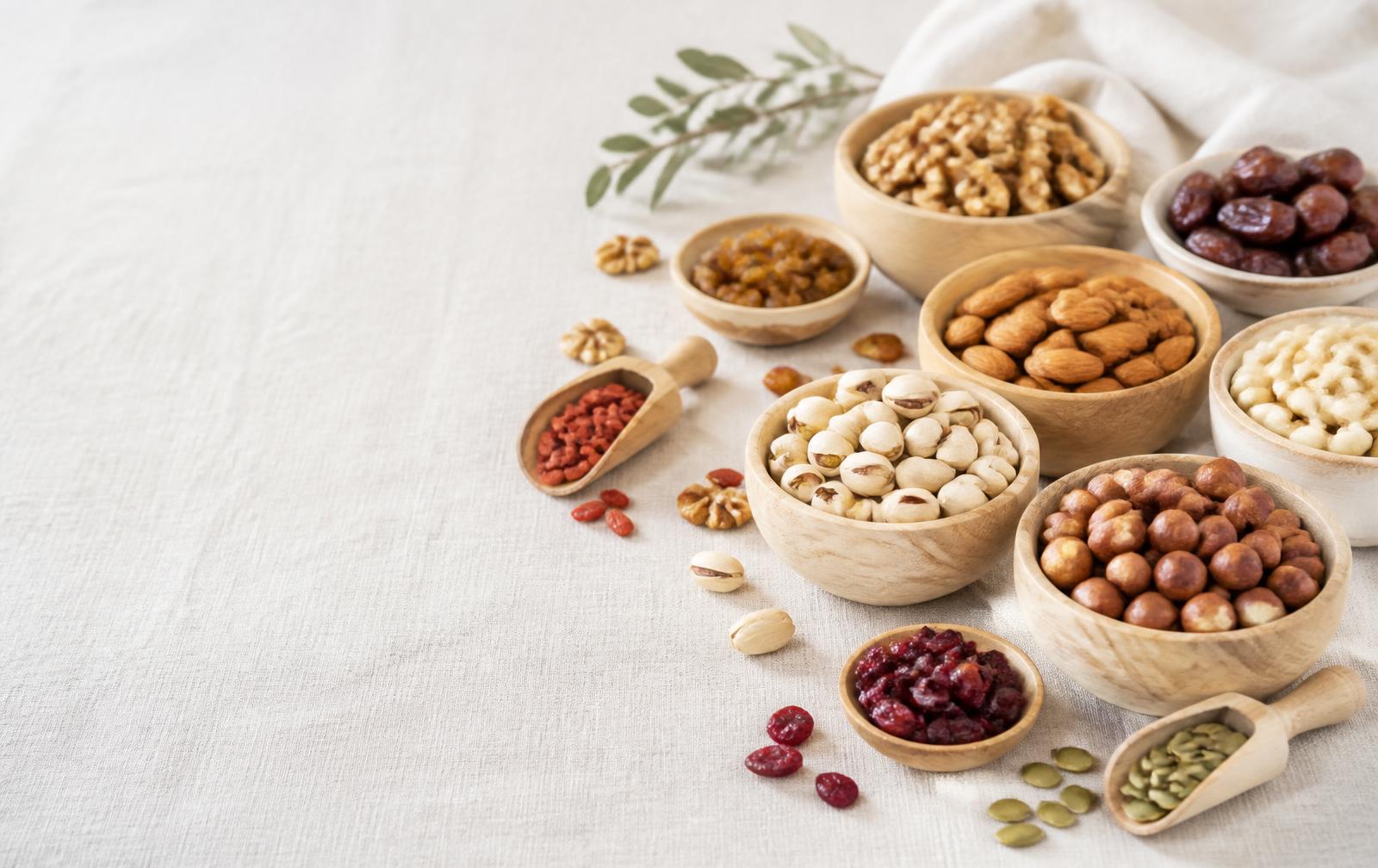 Assortment of nuts and dried fruits in wooden bowls